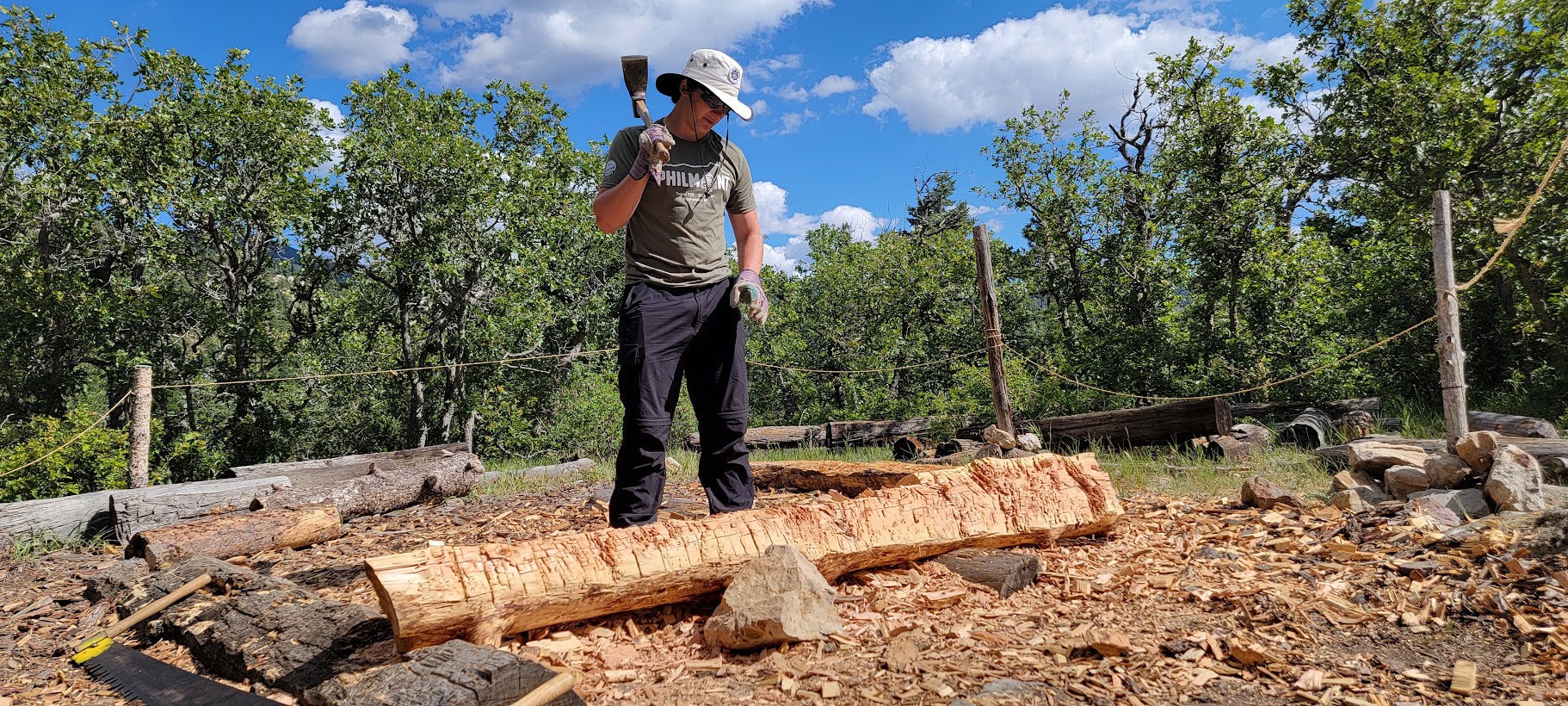 Ashton Keith hewing timber outdoors